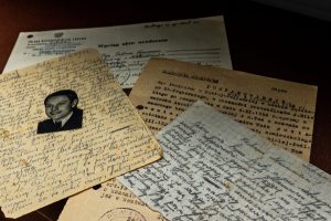 Zdjęcie starych dokumentów zokresu wojennego i powojennego nałożonych jeden na drugim.